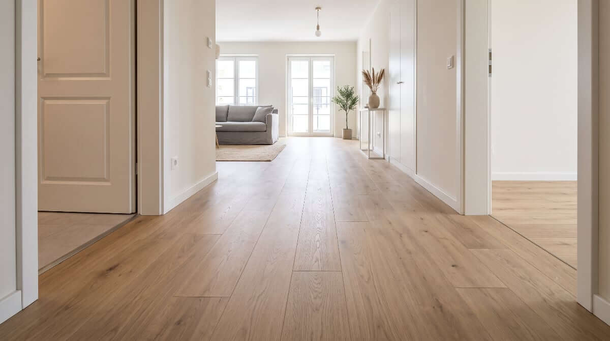 Wood-look laminate flooring in a modern hallway opening into a bright living space