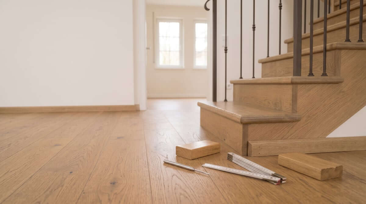 Renovated timber stair with matching parquet flooring and measuring tools — scope of stair renovation services